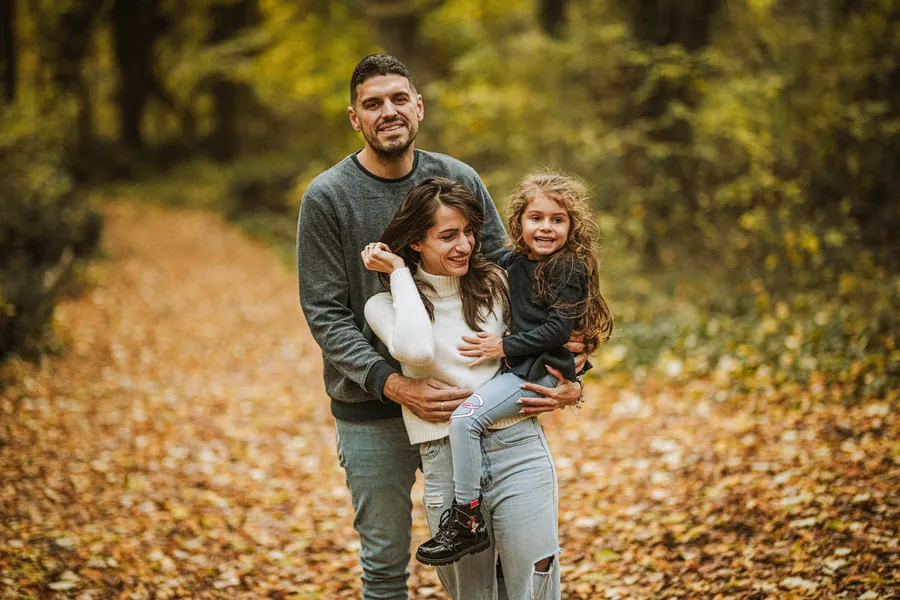 Familienportraet auf dem Waldweg im Herbstlicht